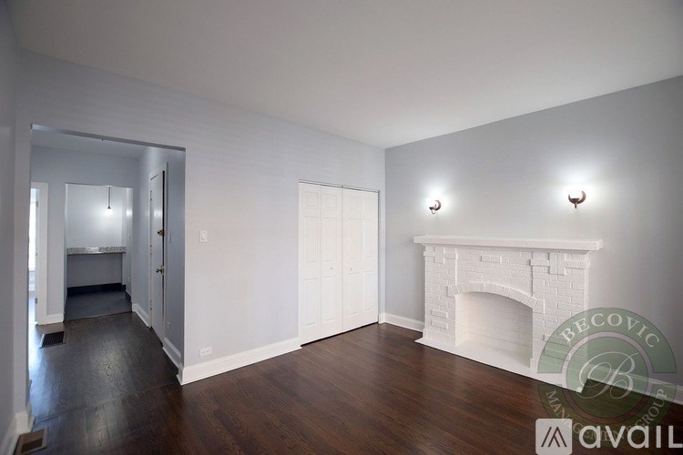 A living room with a fireplace and wood floors.