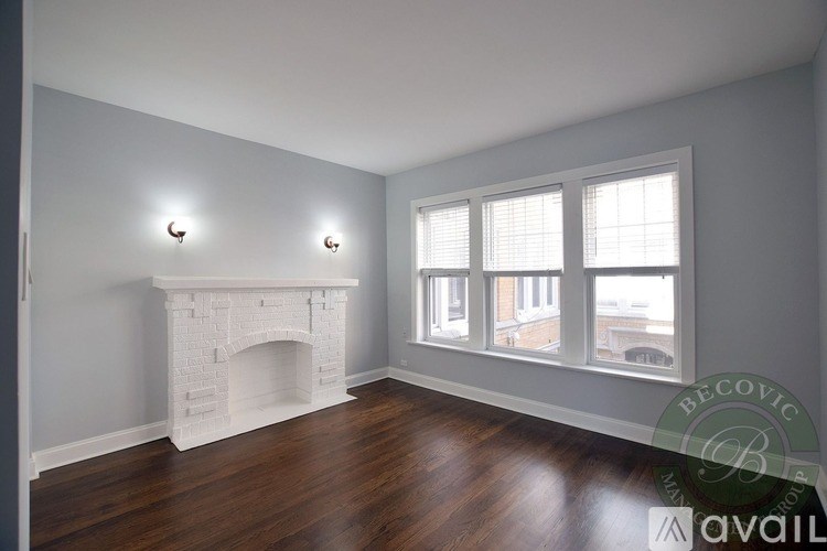 A living room with a fireplace and two windows.