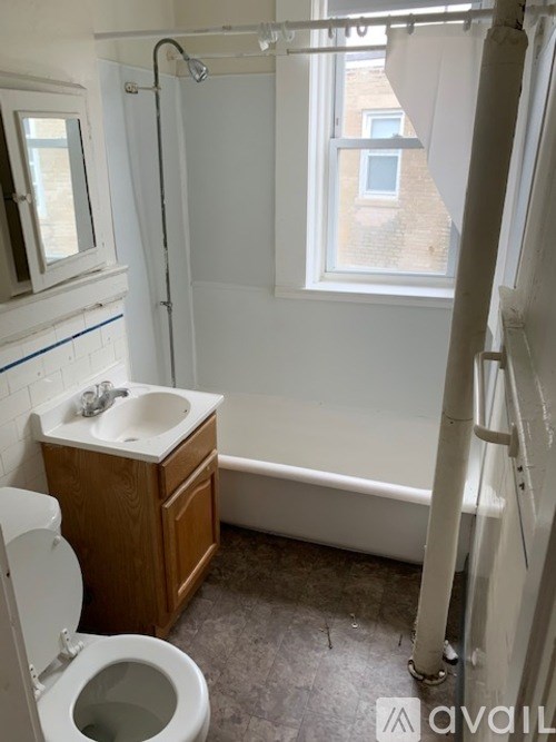A bathroom with a toilet, sink, and bathtub.
