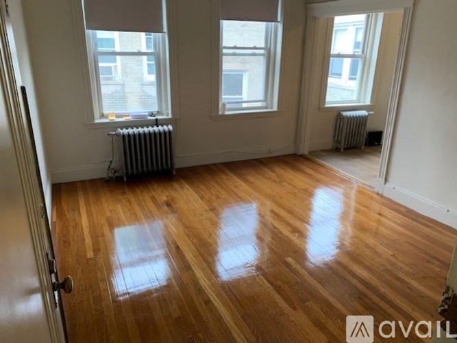 A room with wooden floors and two windows.