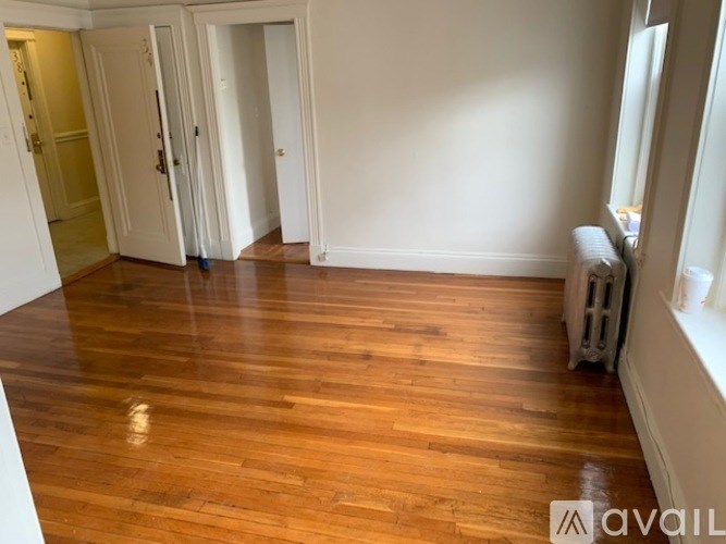 A room with wooden flooring and white walls.