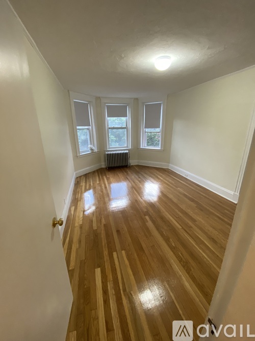 A room with wooden flooring and white walls.