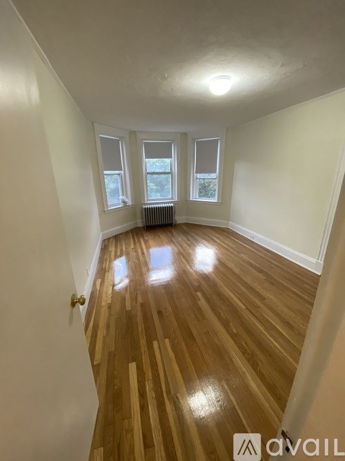 A room with wooden flooring and white walls.