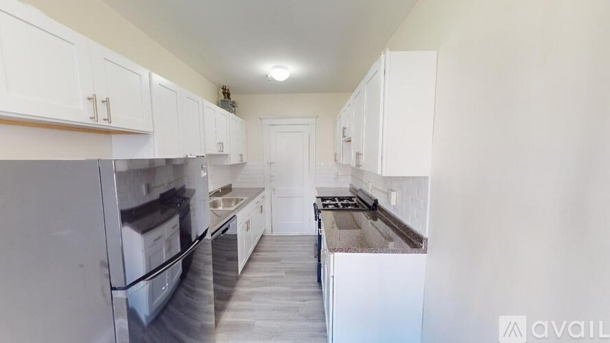 A kitchen with white appliances and cabinets.
