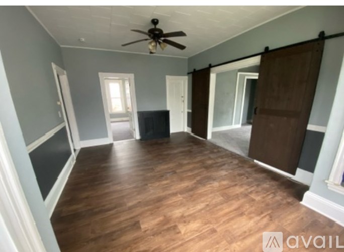 A room with wooden floors and a ceiling fan.