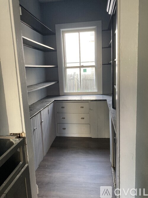 A kitchen with a window, cabinets and drawers.
