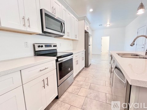 A kitchen with white cabinets and appliances.