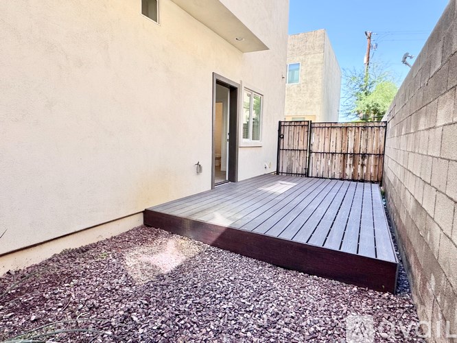 A house with a wooden deck and a black gate.