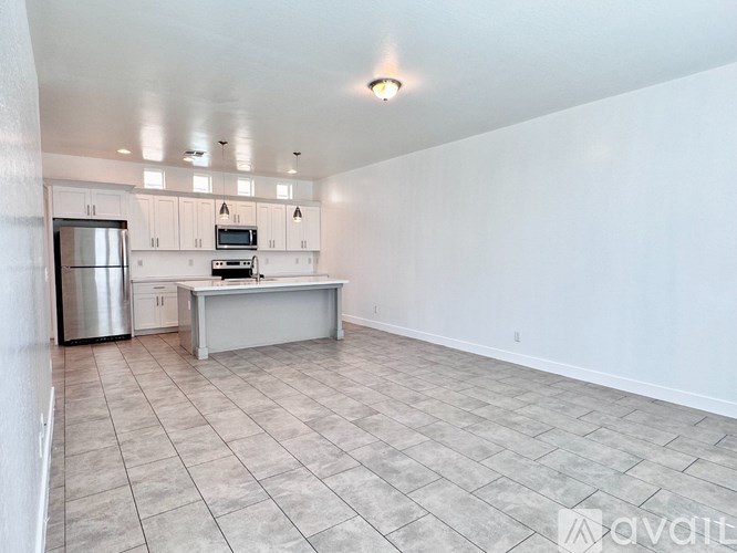 A kitchen with a refrigerator, microwave, and oven is available for rent.