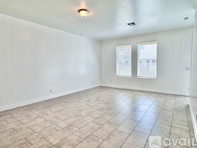 A room with tiled flooring and a window with blinds.