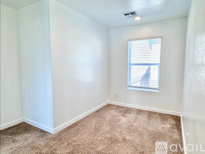 A room with a window and carpeted floor.