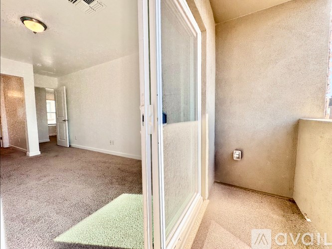 A room with a carpet and a glass door.