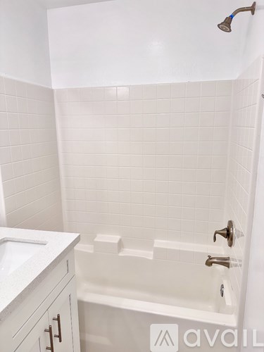A white bathroom with a white tub and a white sink.