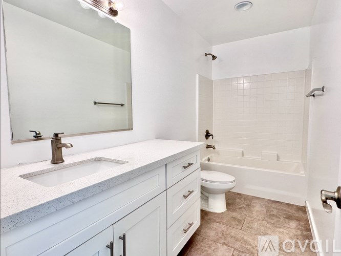 A white bathroom with a sink, toilet, and bathtub.