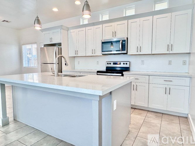 A kitchen with a white countertop and a stainless steel refrigerator.
