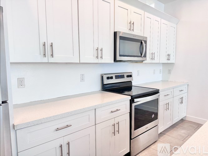 A kitchen with white cabinets and appliances.