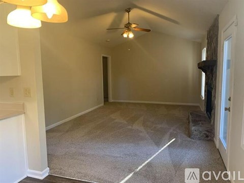 A room with a ceiling fan and carpeted floor.