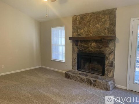 A stone fireplace with a brown patterned screen above it.