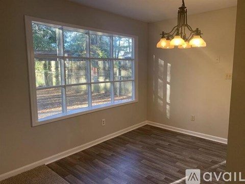 A room with a large window and a chandelier.