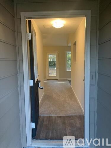 A hallway with a door open to a balcony.