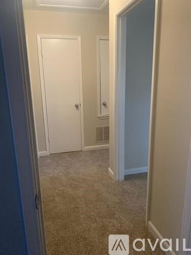 A hallway with two doors and a carpeted floor.