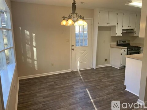 A kitchen with a white door and a chandelier.