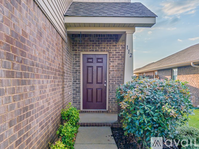 A house with a brown door and a brick wall.
