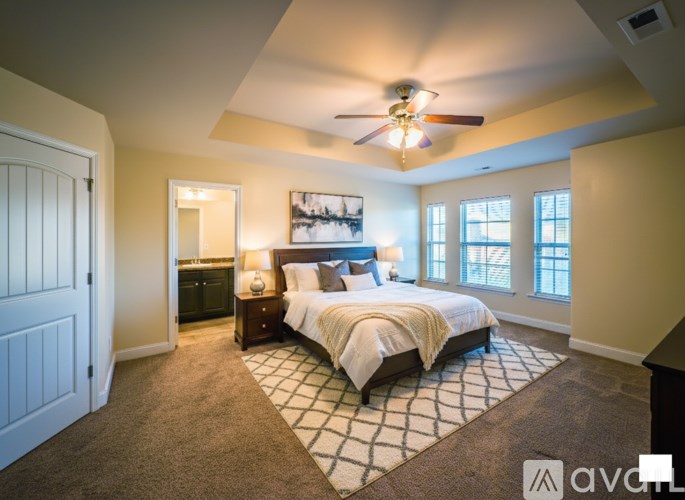 A bedroom with a large bed and a ceiling fan.