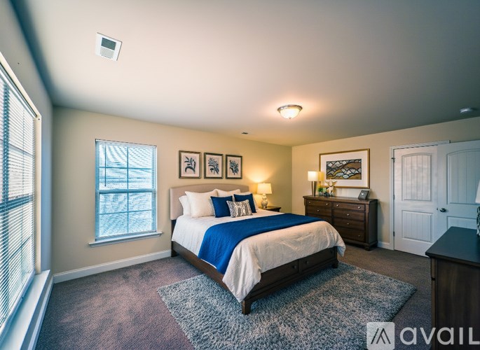 A bedroom with a bed, dresser, and window.