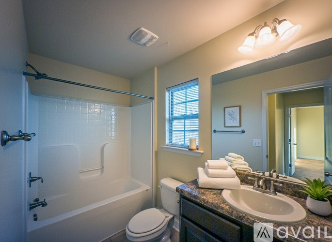 A bathroom with a toilet, sink, and bathtub.