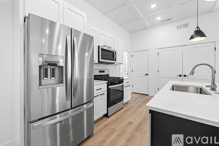 A modern kitchen with a stainless steel refrigerator and white countertops.