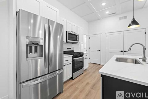 A modern kitchen with a stainless steel refrigerator and white countertops.
