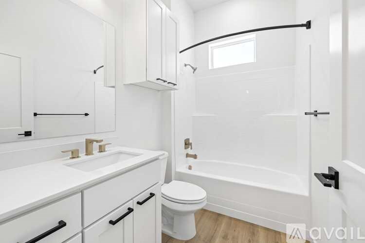 A white bathroom with a toilet, sink, and bathtub.