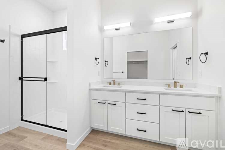 A bathroom with a white vanity and a large mirror.