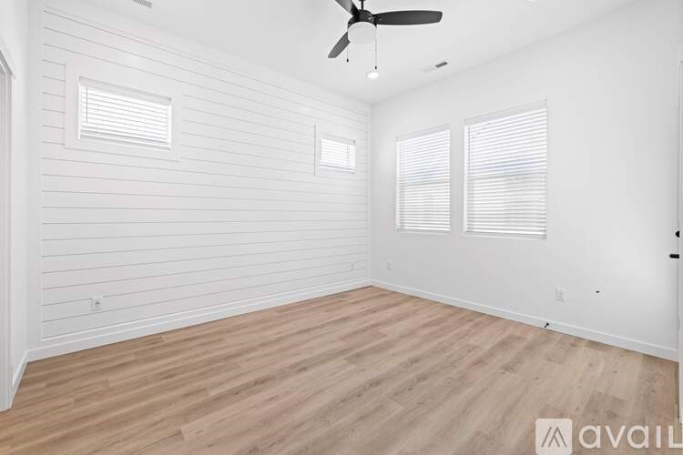 A room with wooden flooring and a ceiling fan.