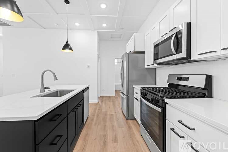 A modern kitchen with black and white appliances and cabinets.