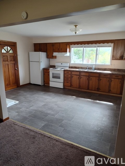 A kitchen with wooden cabinets and a white fridge.