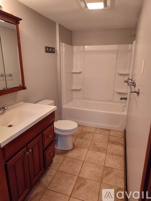 A bathroom with a toilet, sink, and bathtub.