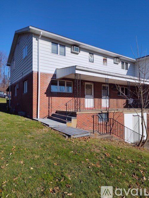 A two-story house with a red brick exterior and a white siding.
