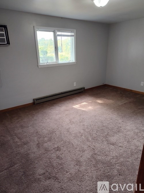 A room with a carpeted floor and a window.