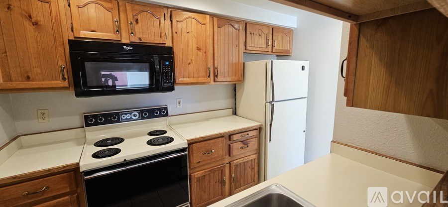 A kitchen with wooden cabinets and a black stove top oven.