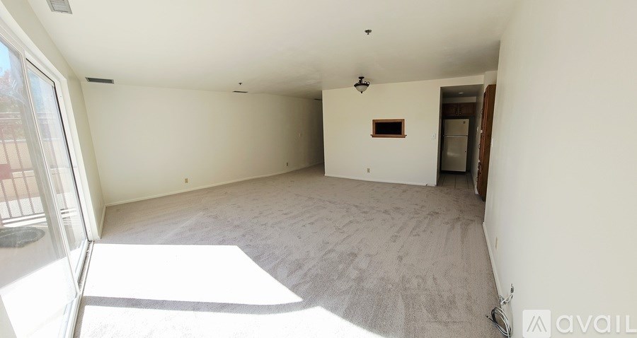 A room with white walls and a carpeted floor is available for rent.