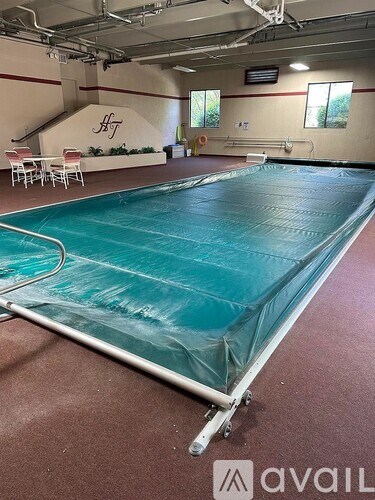 A large indoor swimming pool covered with a blue tarp.