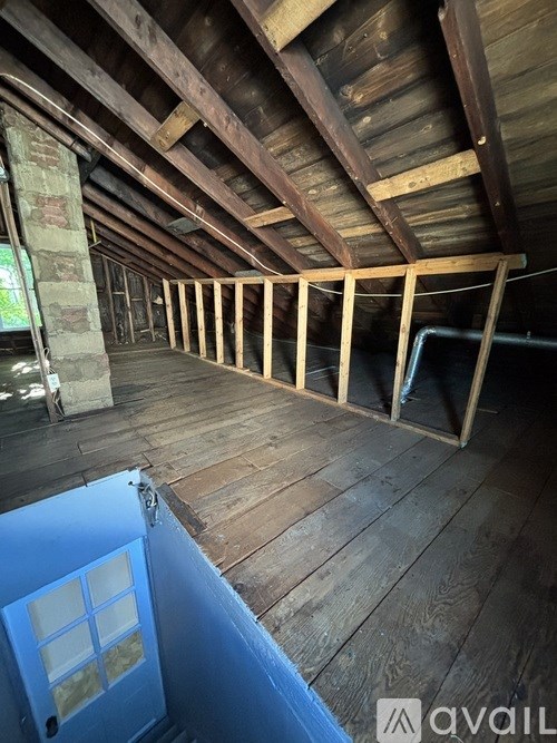 A room with wooden floors and a blue door is under construction.