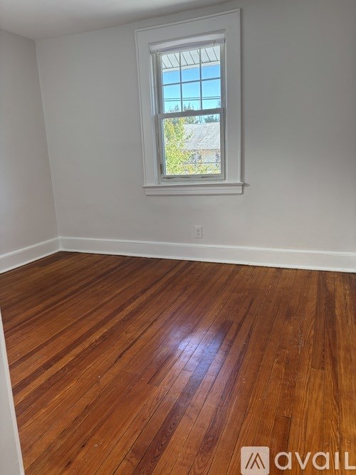 A room with wooden flooring and a window.