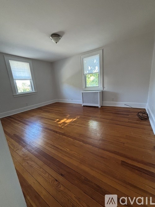 A room with wooden flooring and a window.
