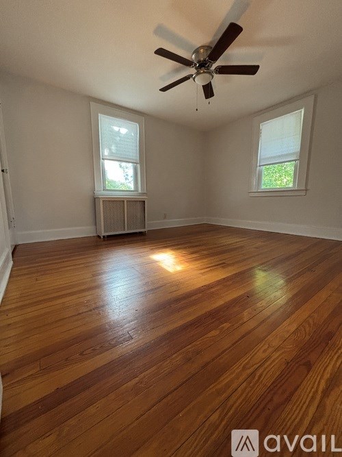 A room with wooden floors and a ceiling fan.