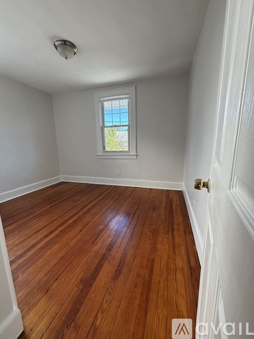 A room with wooden flooring and a window.