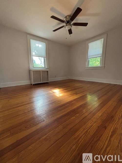A room with wooden flooring and a ceiling fan.