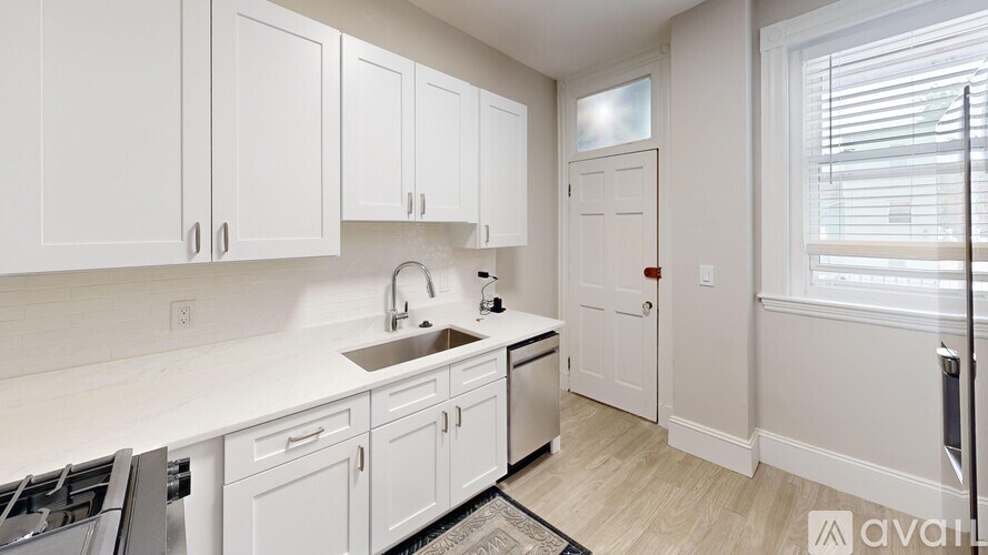 A kitchen with white cabinets and a sink.
